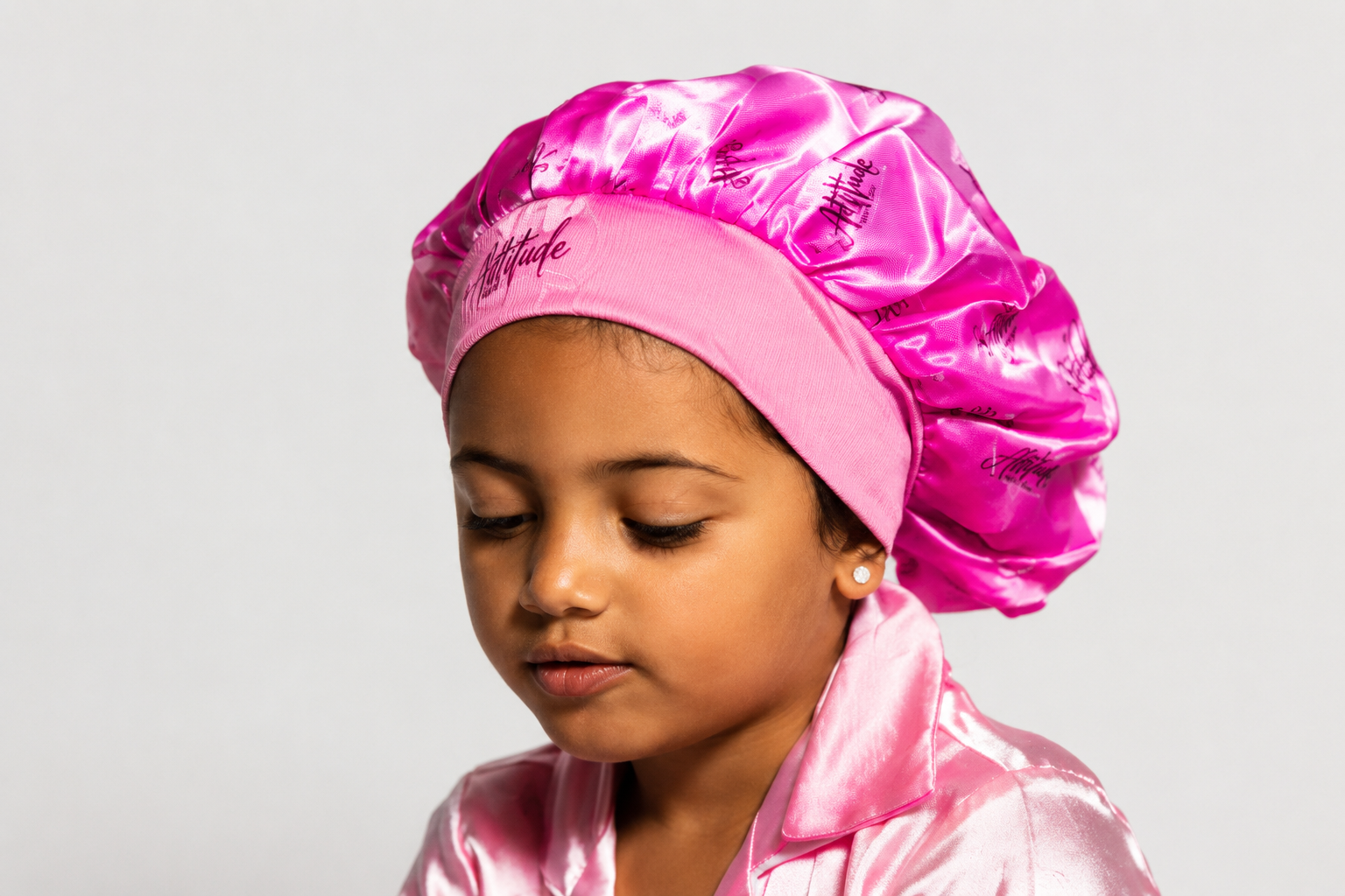 Child wearing the 360 Attitude premium tie/bow satin bonnet