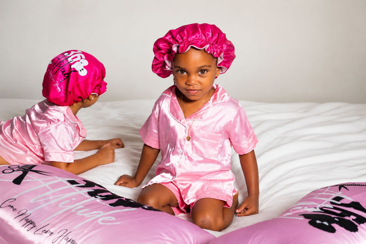 Children wearing 360 Attitude classic satin bonnets with matching satin pajamas